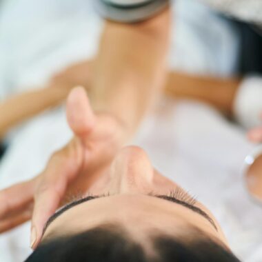 Close-up view of a professional makeup artist applying cosmetics indoors, highlighting beauty and skin care.